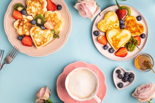 Valentijnsdag plat lag met hartvormige pannenkoeken op een blauw. Valentijnsdag concept. Uitzicht van boven.