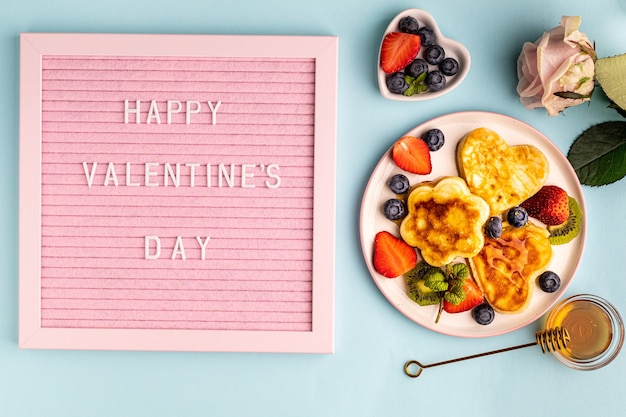 Valentijnsdag plat lag met hartvormige pannenkoeken op een blauw. Valentijnsdag concept. Uitzicht van boven.