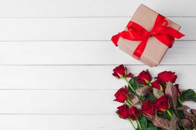 Valentijnsdag. Rode rozen en geschenkdoos op houten tafel