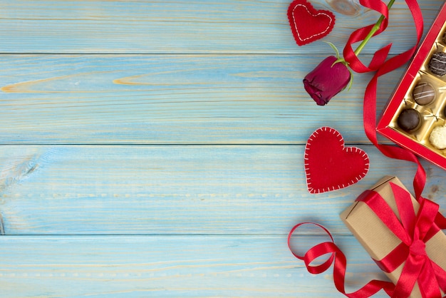 Valentijnsdag romantische decoratie met rozen en chocolade op een blauwe houten tafel.