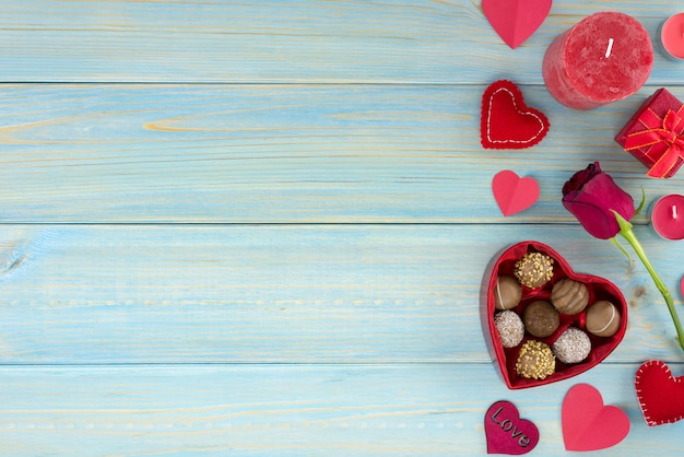 Valentijnsdag romantische decoratie met rozen en chocolade op een blauwe houten tafel.