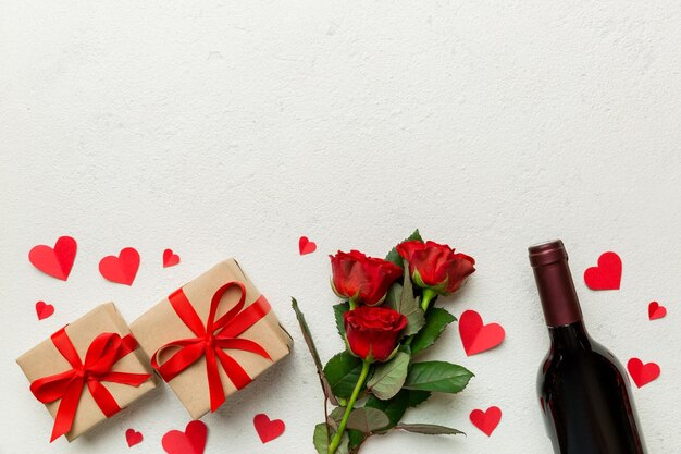 Valentijnsdag samenstelling met rode wijn roze bloem en geschenkdoos op tafel Bovenaanzicht plat leggen Concept vakantie