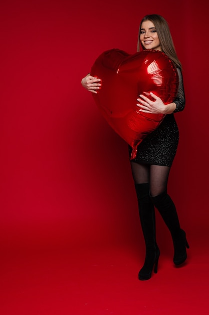 Foto valentijnsdag vieren jong lachend meisje koestert hartvormige ballon