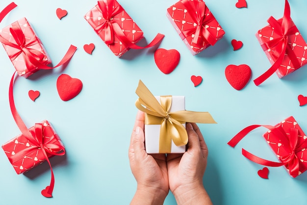 Valentijnsdag. Vrouw handen met geschenk of huidige doos ingericht