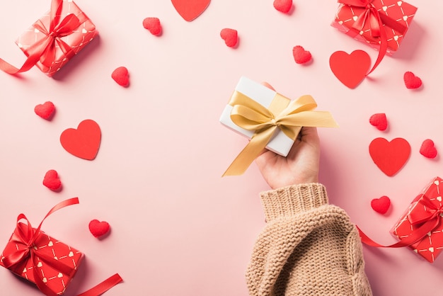 Valentijnsdag. Vrouw handen met geschenk of huidige doos ingericht