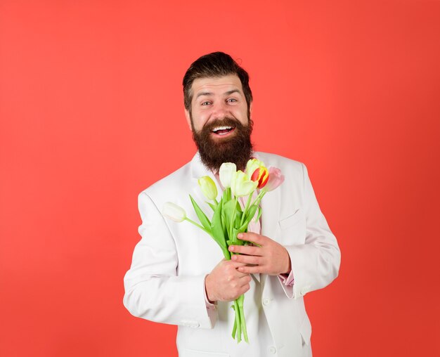 Valentijnsdag vrouwen dag verjaardag knappe man bloemen zakenman met boeket tulpen voor