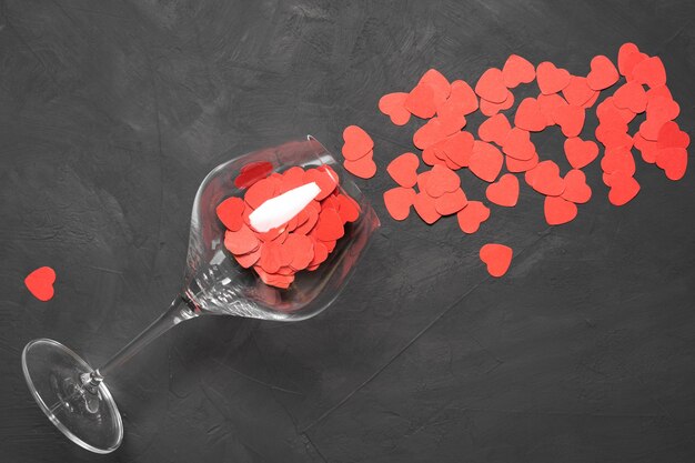 Valentijnsdag wenskaart met wijnglazen en harten op stenen achtergrond. Bovenaanzicht met een plek voor uw groeten. Vlakke la