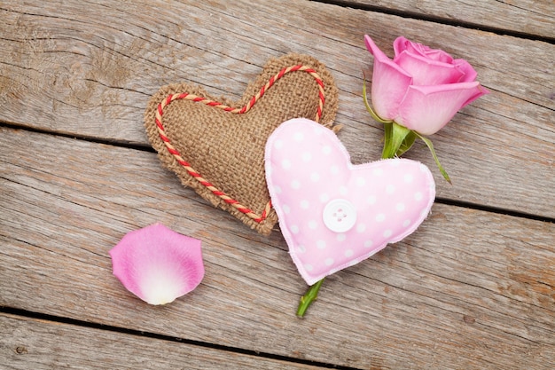 Foto valentijnsdagkaart met roze roos en handgemaakt speelgoedhart