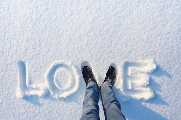 Valentijnskaart met het woord liefde in de sneeuw. Feestelijke achtergrond met kopieerruimte