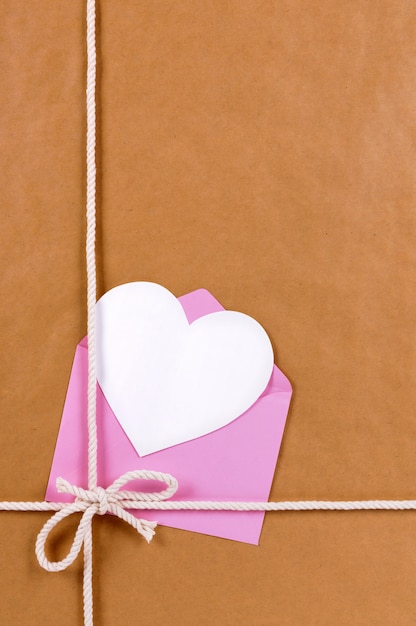 Photo valentine card on a brown paper package or gift tied with string.