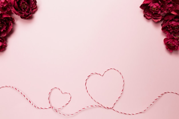 Photo valentine card. heart shapes. red white string or rope. roses. pink background. high quality photo