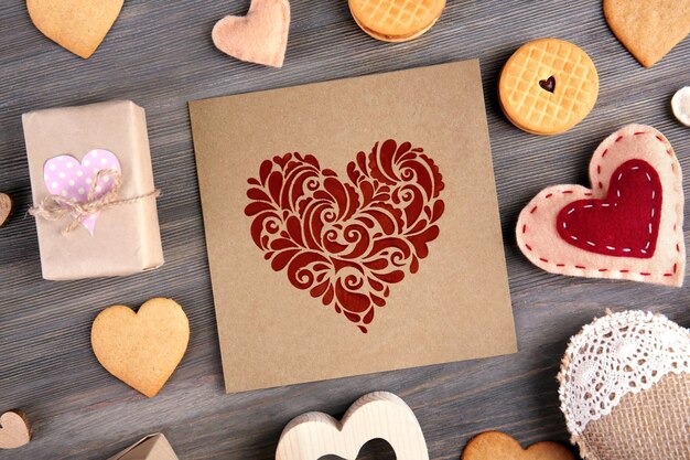 Photo valentine concept card with gift boxes and cookies on wooden table background