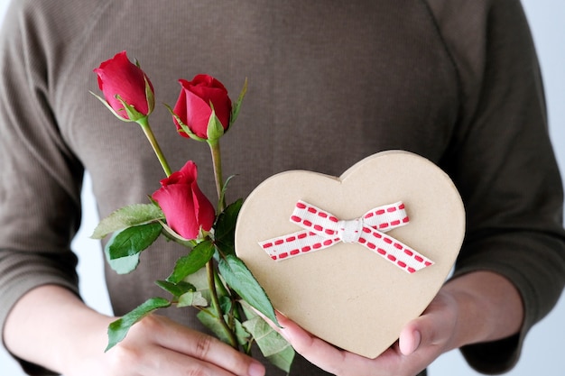 Valentine-concept, Mensenhand die rode rozen en giftdoos houden