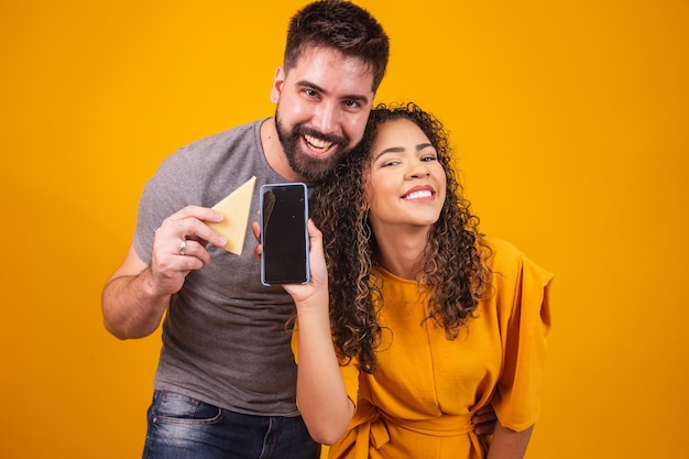 Valentine couple campaigning for cheese brand. Happy Valentine couple with cheese and cellphone with blank screen