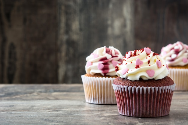 Valentine cupcakes met liefjes op houten lijst wordt verfraaid copyspace die