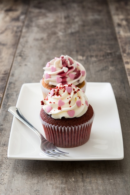 Valentine cupcakes versierd met liefjes op houten tafel