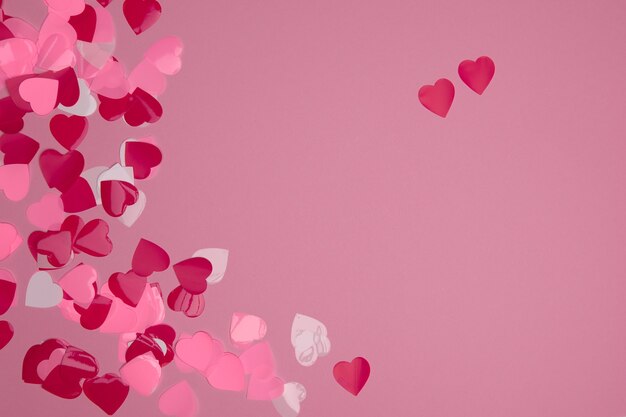 Valentine day composition with copy space. Frame made of confetti hearts red and pink on pastel background. Close up, top view, copy space