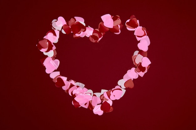 Photo valentine day composition with copy space. frame made of confetti hearts red and pink on pastel background. close up, top view, copy space