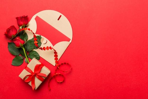 Valentine day composition with envelope rose flower and red heart on table Top view flat lay copy space Holiday concept