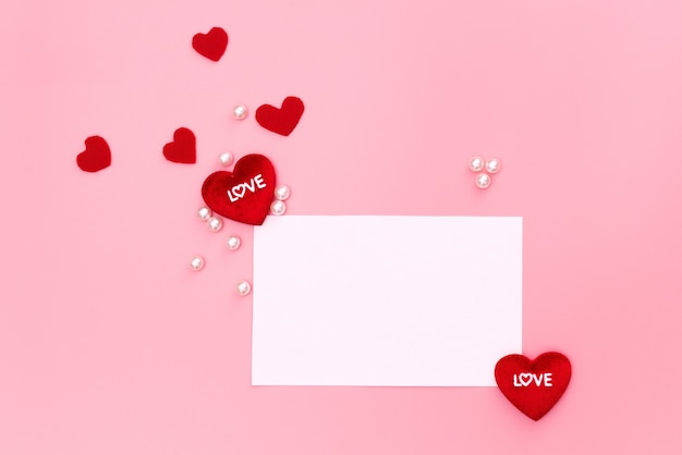 Valentine day concept, red hearts and white note on pink background