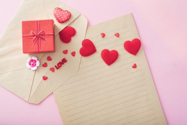 Photo valentine day gift box and red hearts on letter envelope