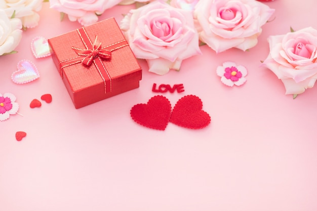 Valentine Day gift box with red hearts and roses on pink background