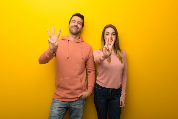 Photo in valentine day group of two people on yellow background happy and counting three with fingers