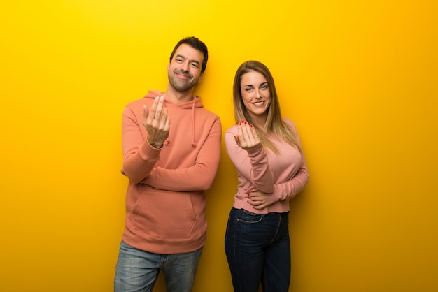 In valentine day Group of two people on yellow background inviting to come with hand. Happy that you came