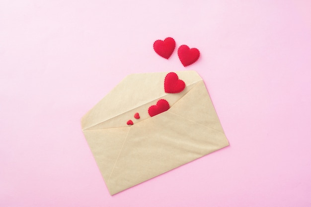 분홍색 배경에 편지 봉투와 발렌타인 데이 레드 심장