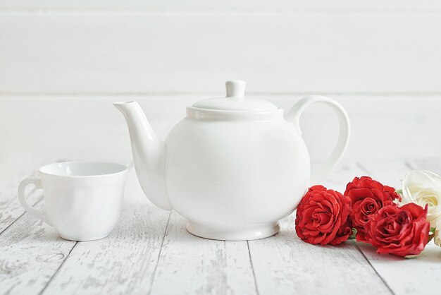 Foto colazione romantica di san valentino con rose rosse e teiera. buon san valentino biglietto di auguri.