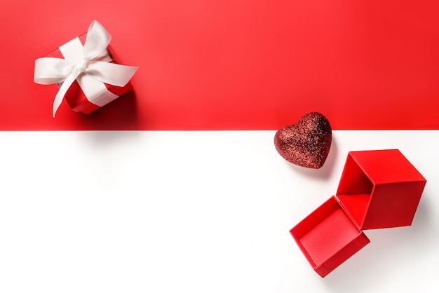 Valentine flat lay. Gift boxes and a heart on a red and white with copy space.