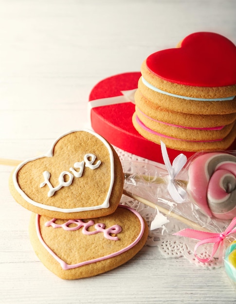 木製の背景にプレゼントボックスとバレンタインハートクッキー