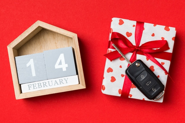 Valentine-kalender en giftdoos met rood lint en zeer belangrijke auto. Plat leggen