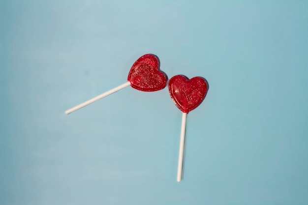 Valentine's card Two lollipops candy as heart on blue background