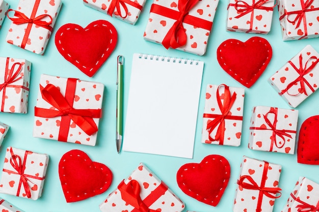 Valentine's composition of notebook, gift boxes and red textile hearts