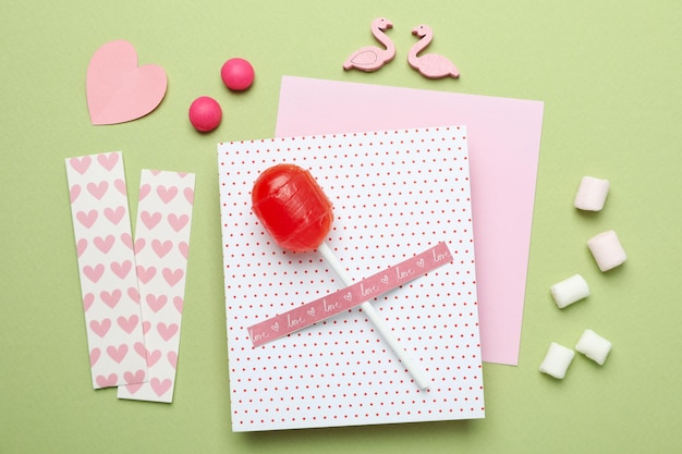 Valentine's Day accessories on green background, top view