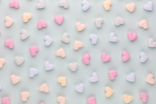 Valentine's Day background. Composition with candy hearts on pastel blue background. Valentines Day greating card. Flat lay, top view.