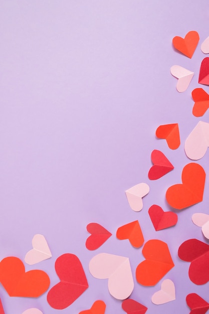 Valentine's Day background. Pink and red hearts on a pastel purple background.