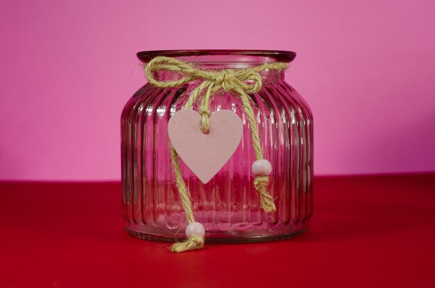Photo valentine's day background. red rose in a glass vase on a pink background.