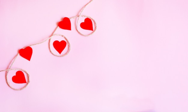 Valentine's day background with red hearts and accessories on pink background.Love shapes background. 