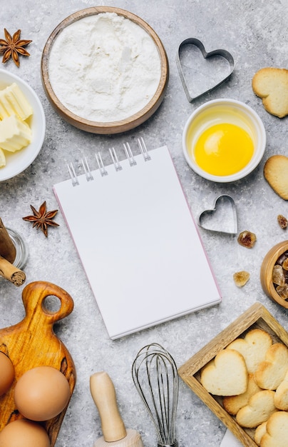 Valentine's Day baking culinary background. Ingredients for cooking on wooden kitchen table, baking recipe for pastry. Heart shape cookies. Top view. Flat lay.