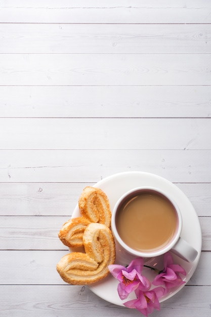 San valentino colazione concetto. cuori dei biscotti e della tazza di caffè su una tavola bianca. copia spazio, disteso.