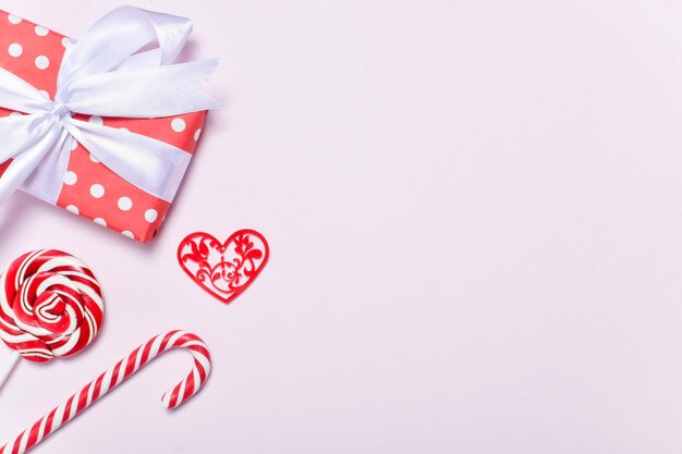 발렌타인 데이 카드입니다. 배너는 축제입니다. 막대 사탕, 선물 및 분홍색 배경에 마음. 공간을 복사합니다. 평평한 평지, 평면도.