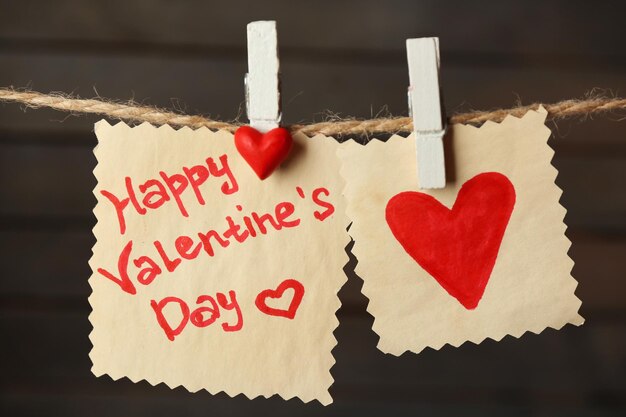 Valentine's Day card with hearts and words of love on wooden background