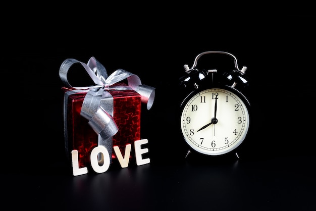 Valentine's day Concept Alarm clock with gift box and Wooden letters word 