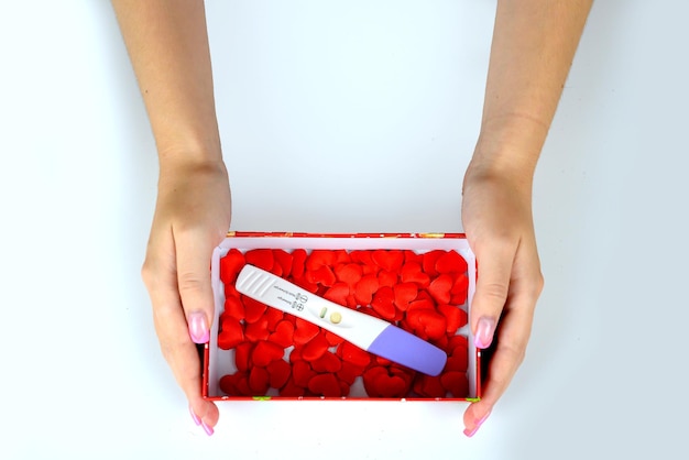 Valentine's Day concept Closeup of female hands packing gifts with red ribbon handmade