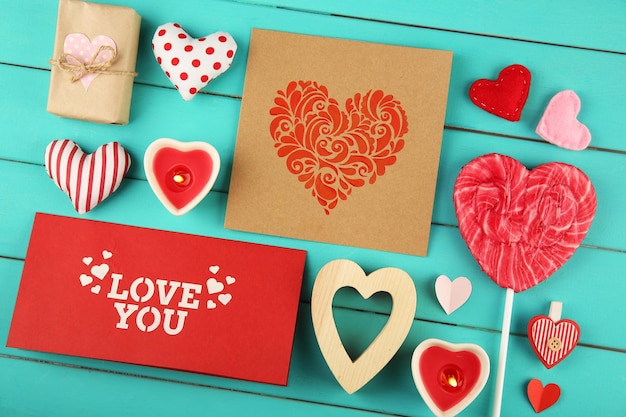 Photo valentine's day concept composition of colourful handmade hearts and gift cards on turquoise wooden background