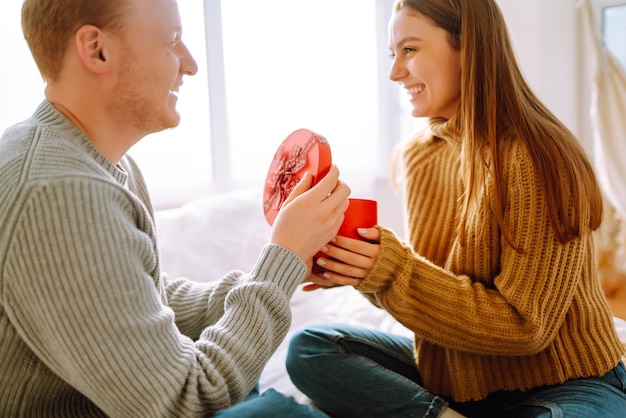 Valentine's Day concept Exchange of gifts Young couple at home celebrating Valentine's Day