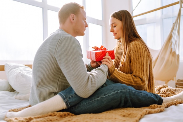 Valentine's Day concept Exchange of gifts Young couple at home celebrating Valentine's Day