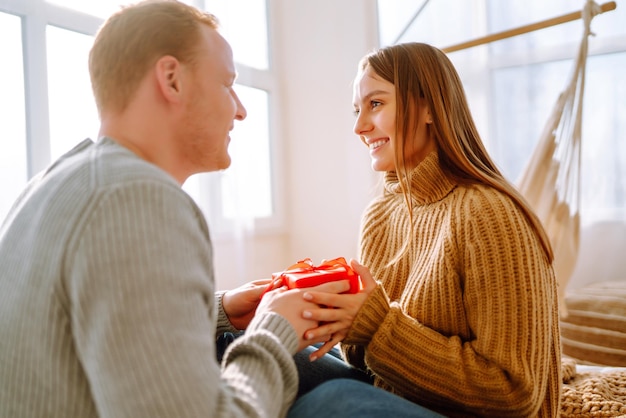 Valentine's Day concept Exchange of gifts Young couple at home celebrating Valentine's Day